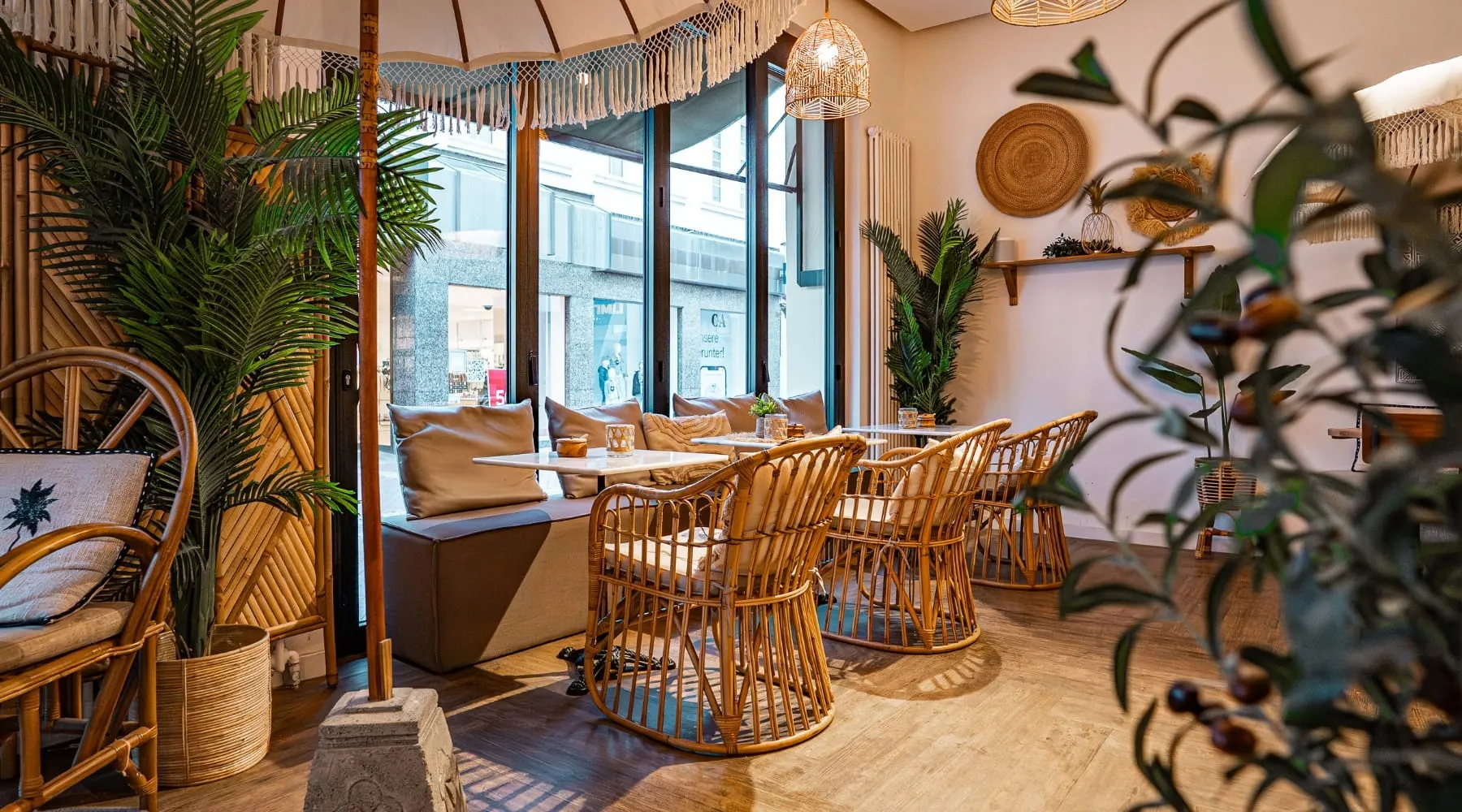 Sitzecke mit Rattanstühlen, Kissen und Pflanzen im Sorella Buer